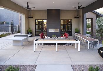 an outdoor patio with tables and chairs and a fireplace